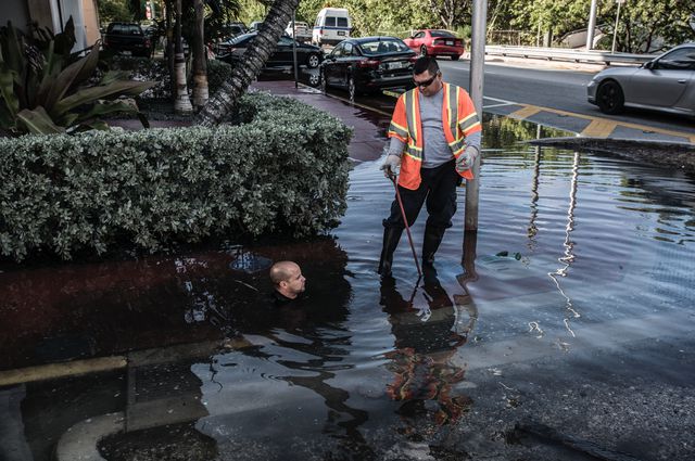 A photo of king tide, the highest predicted tide of the year, in Miami Beach the water comes up over a poorly maintained seawall and through the drainage system into the street.